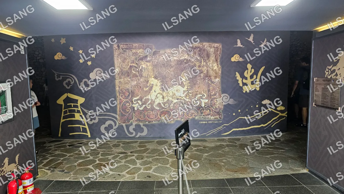 A black and gold painting on a wall.