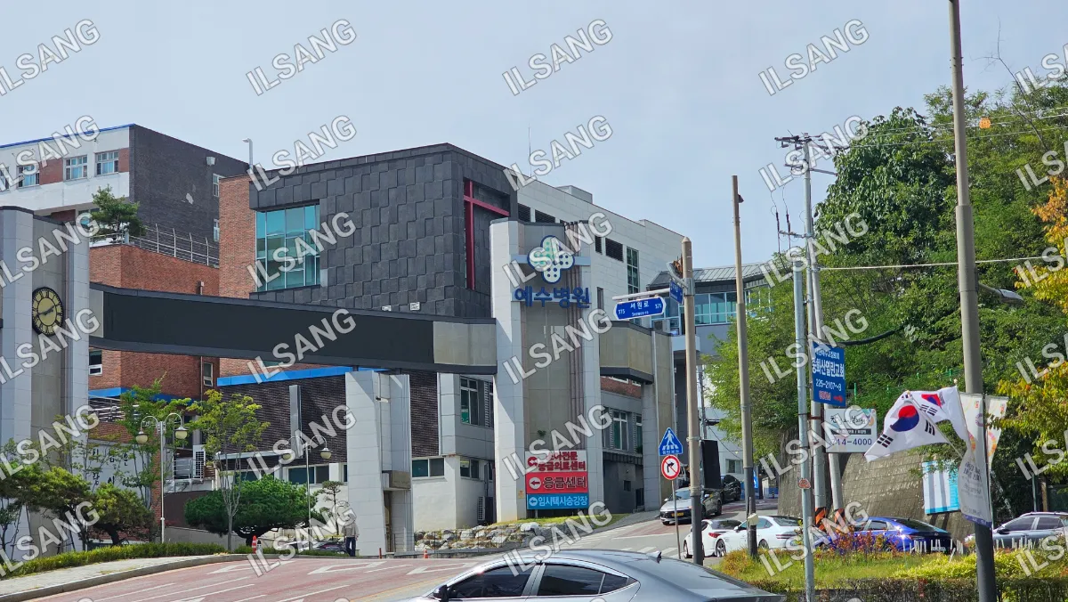 A black car is parked in front of a building.