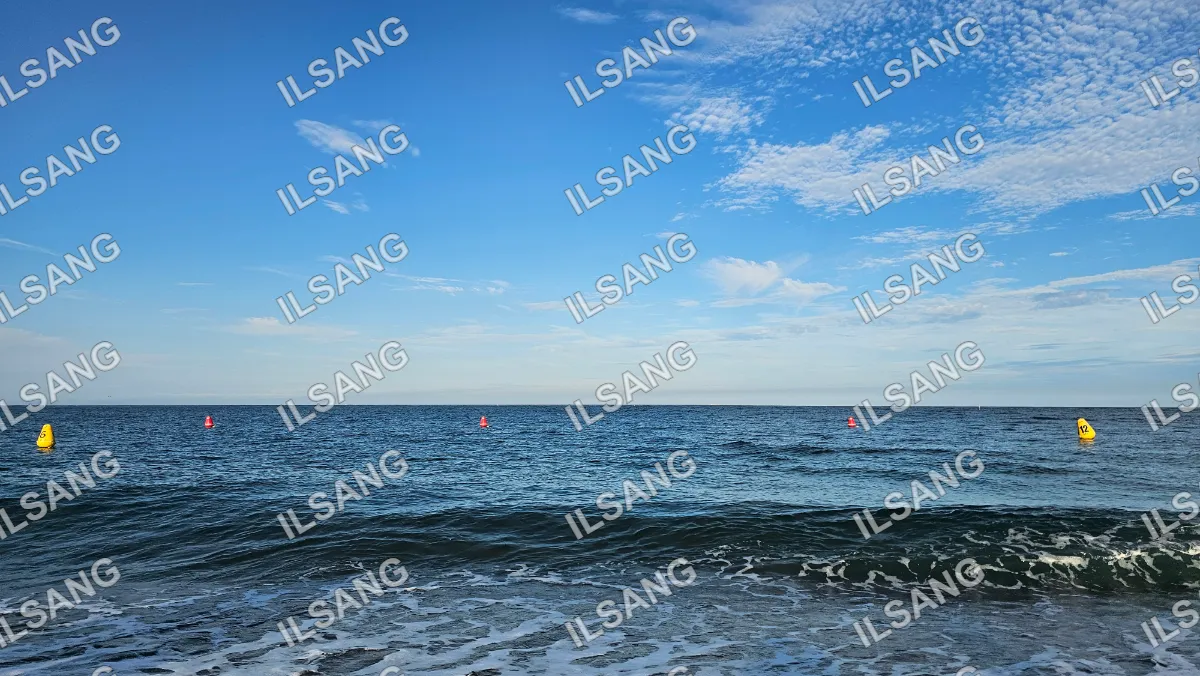 A blue sky with clouds and a body of water.