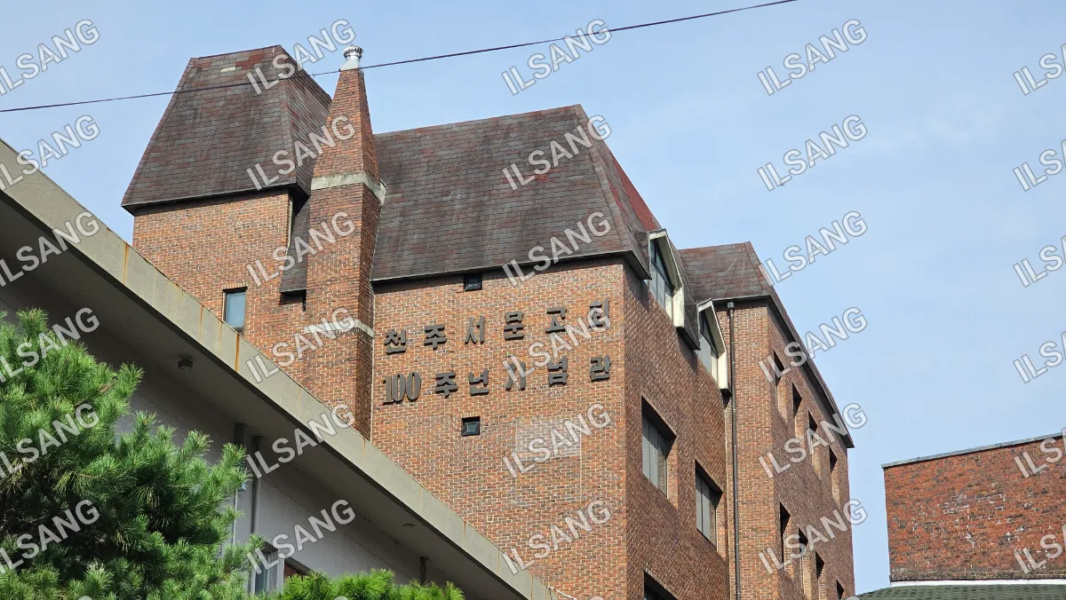 A brick building with a sign on the side that says "100".