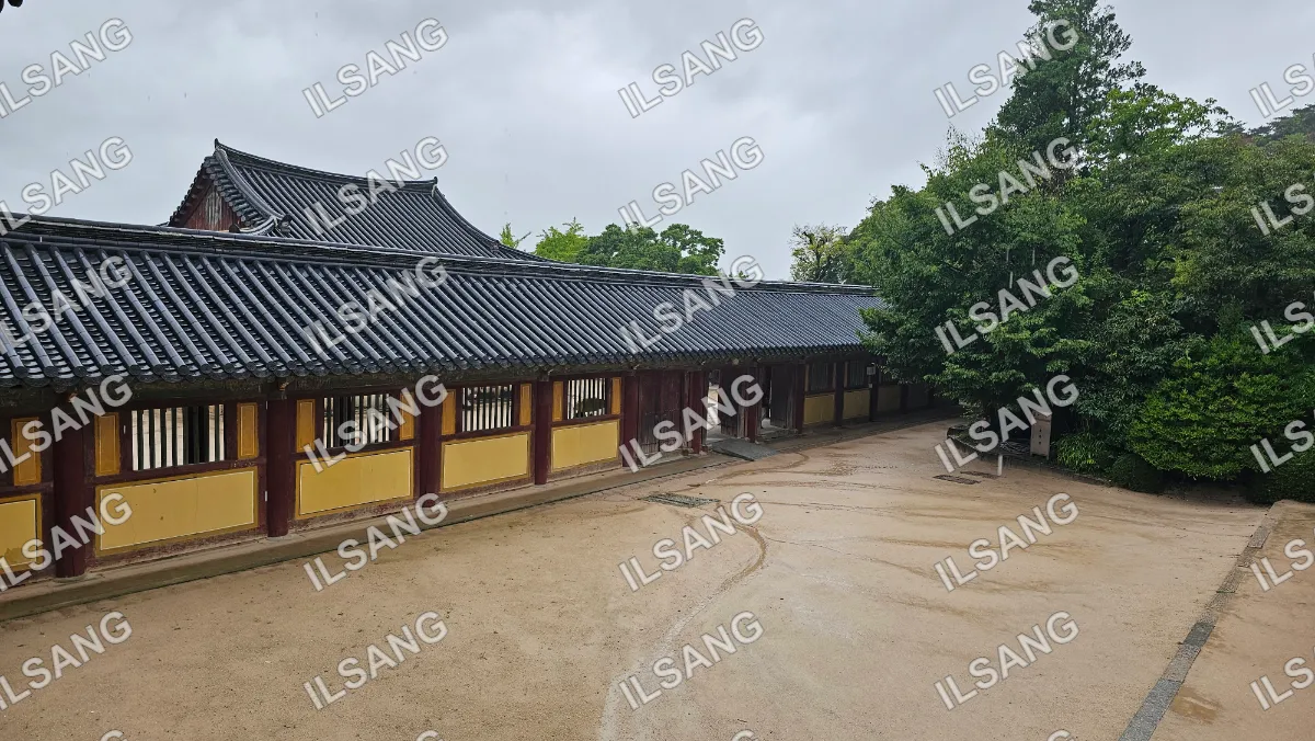 A building with a roof and a fence in front of it.
