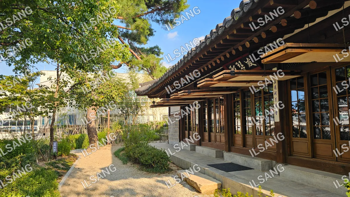 A building with a wooden roof and a tree in front of it.