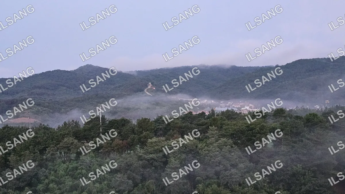 A foggy mountain with a church on top.