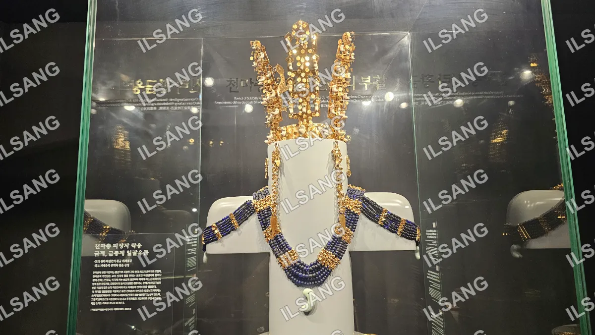 A gold crown is on display in a glass case.