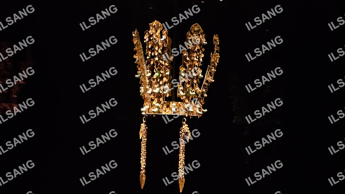 A golden crown with a chain hanging from it.