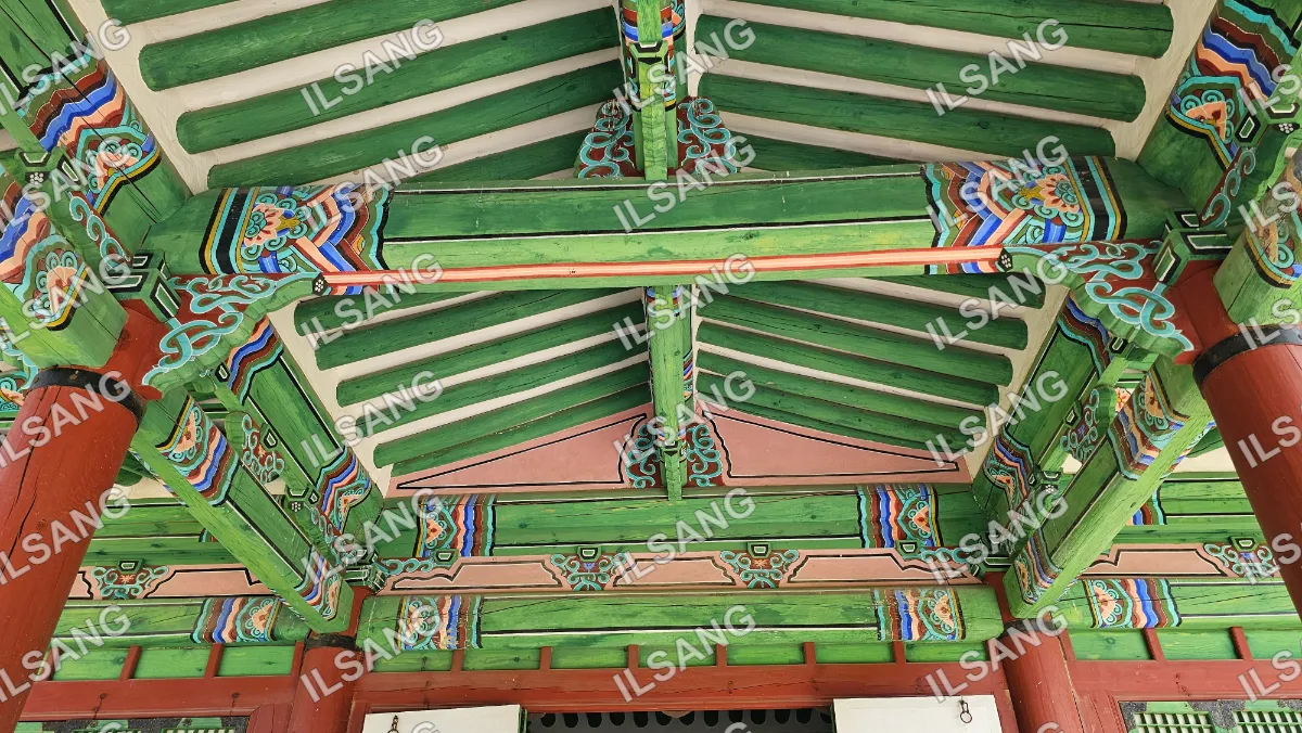 A green wooden ceiling with a cross beam.