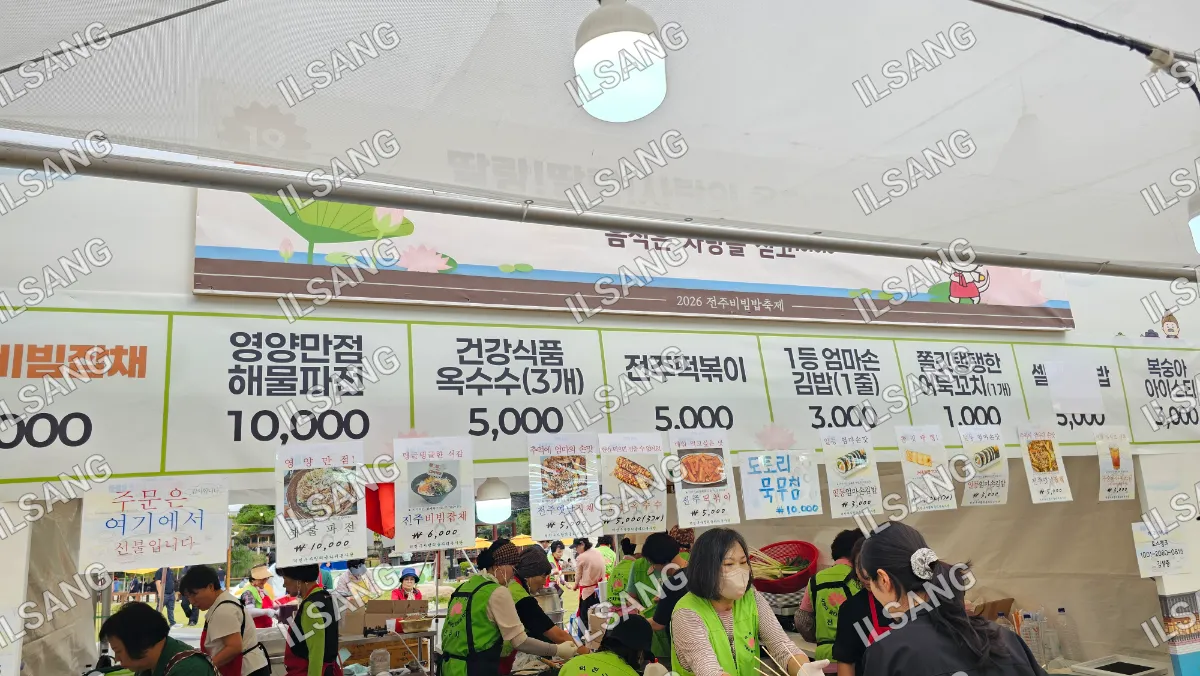 A group of people are shopping at a market with a variety of food items.