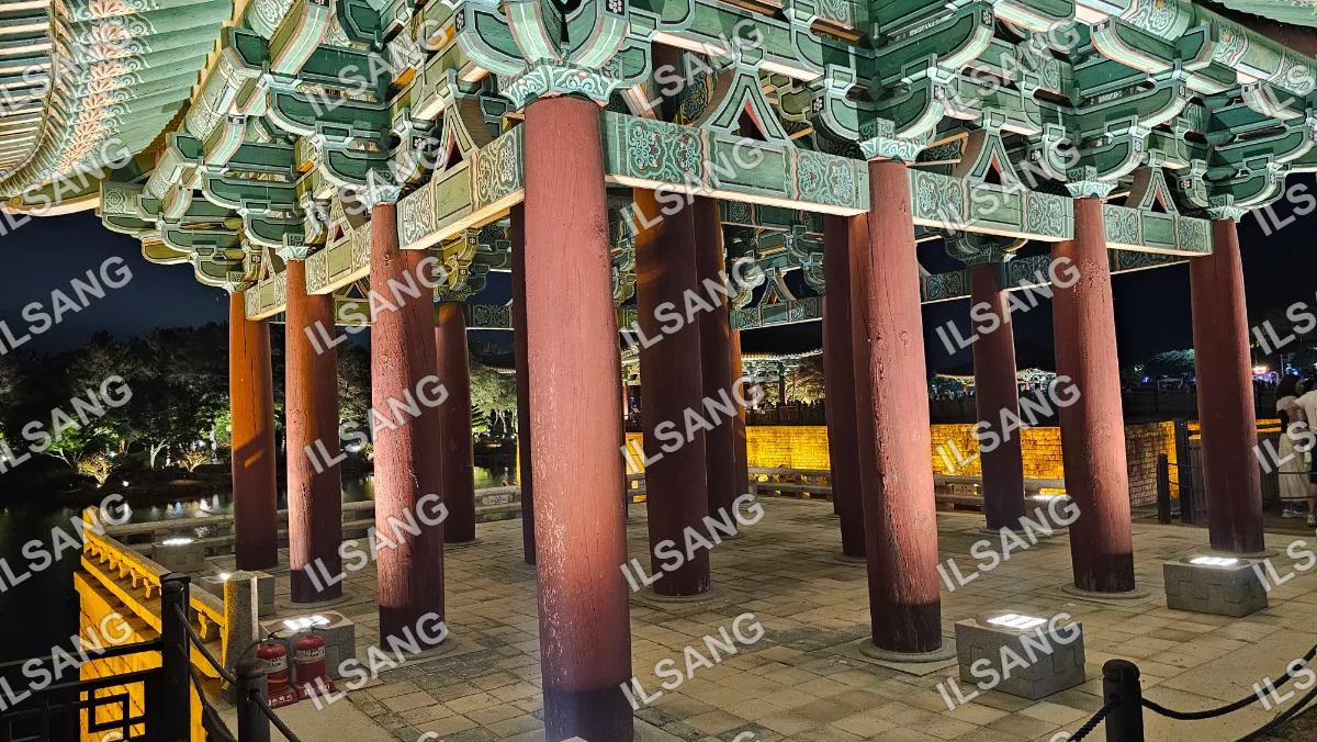 A group of red pillars with green designs on them.