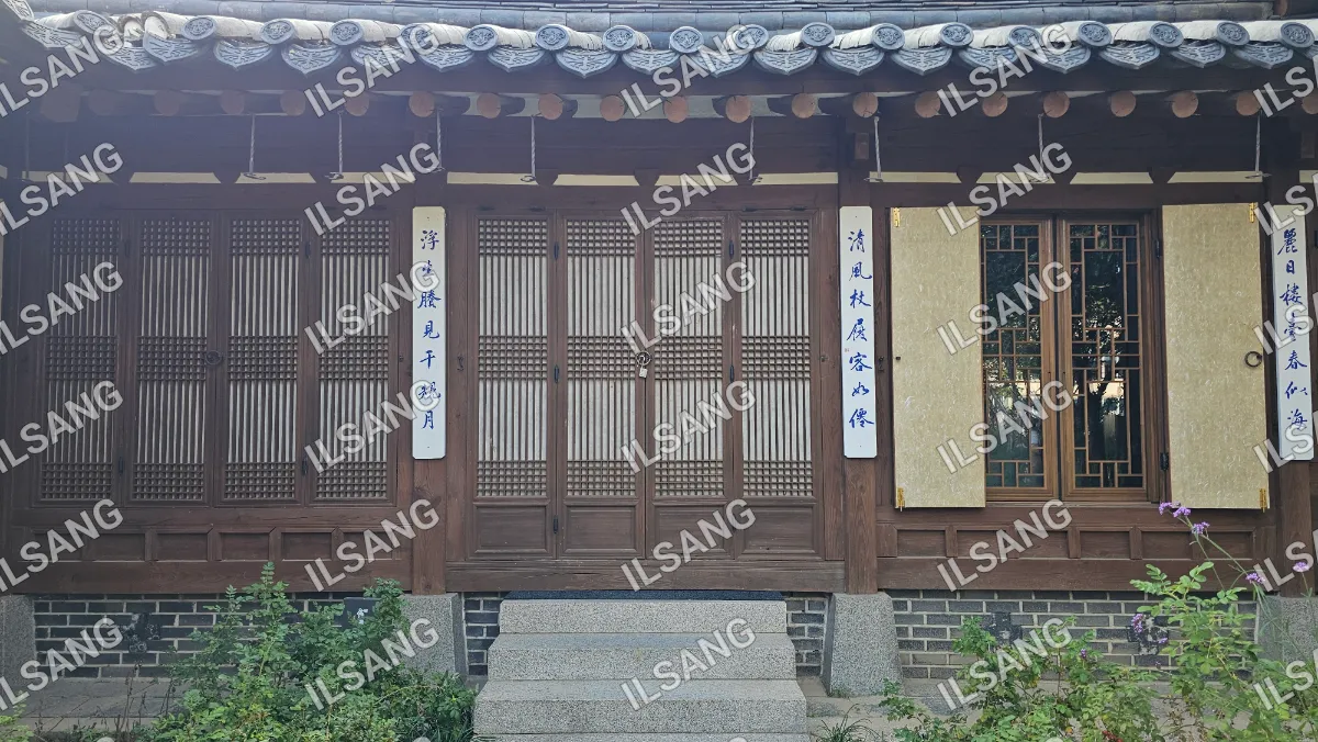 A house with a wooden door and a window with a bamboo shade.