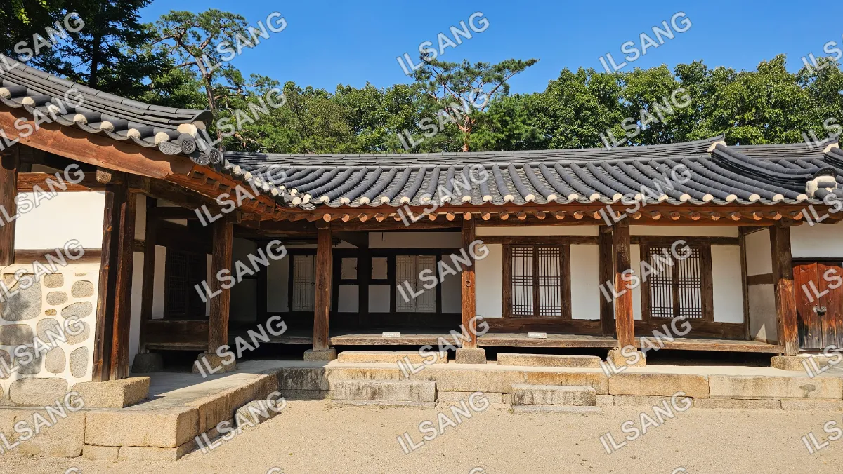 A house with a wooden roof and a stone wall.