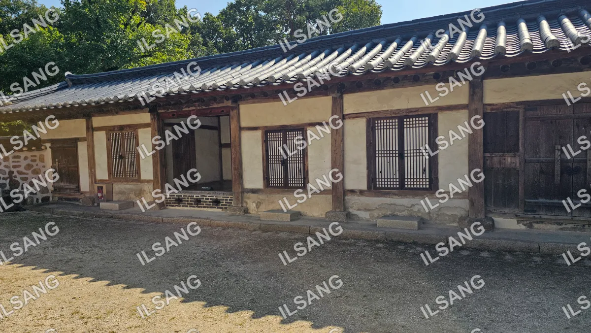 A house with a wooden roof and a stone wall.