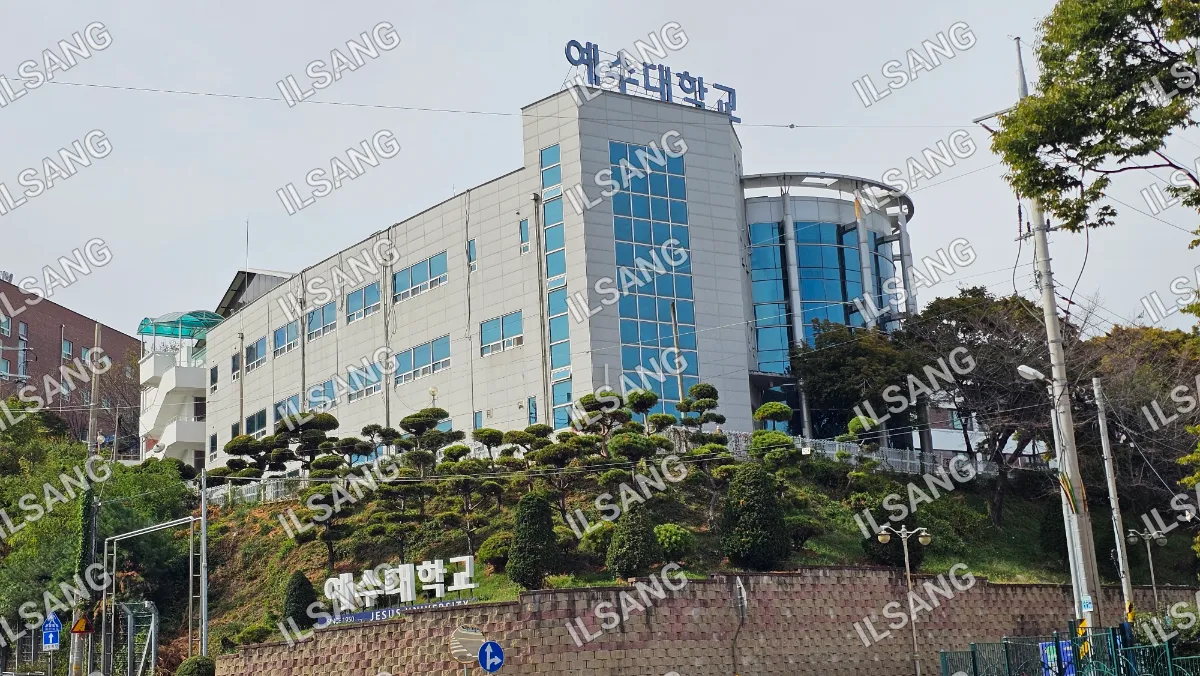 A large building with a blue roof and a sign on top.