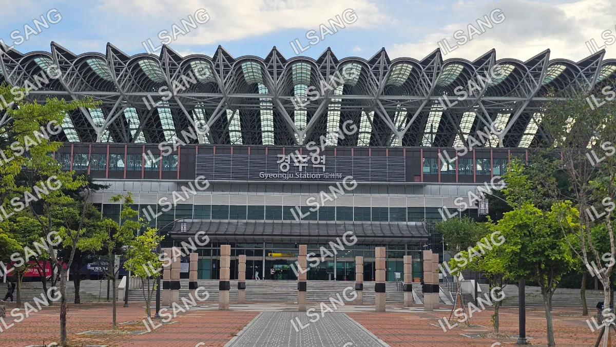 A large building with a glass roof and a sign that says "Gyongju Station".