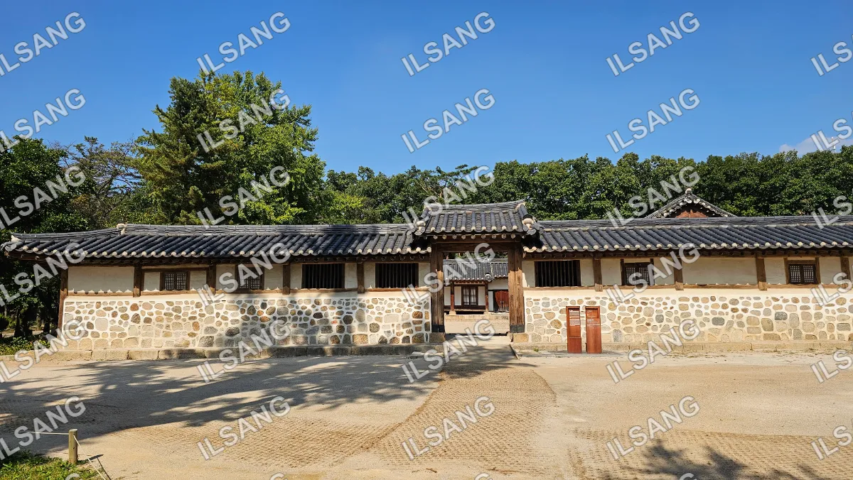 A large building with a stone wall and a wooden roof.