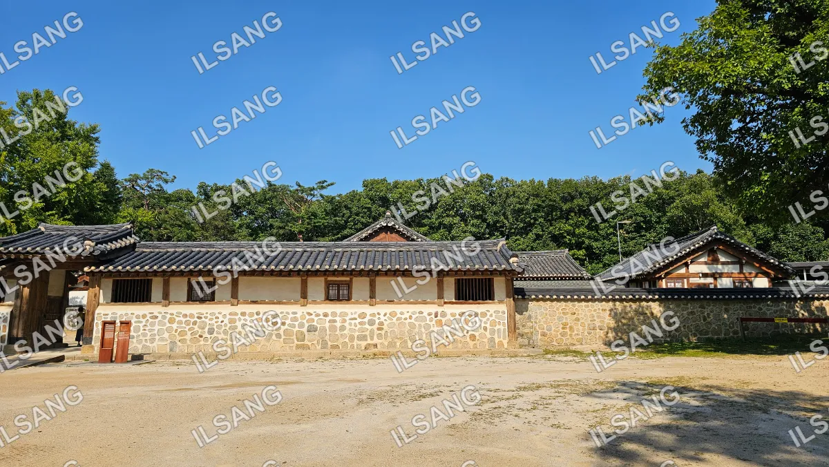 A large building with a tile roof and a stone wall.