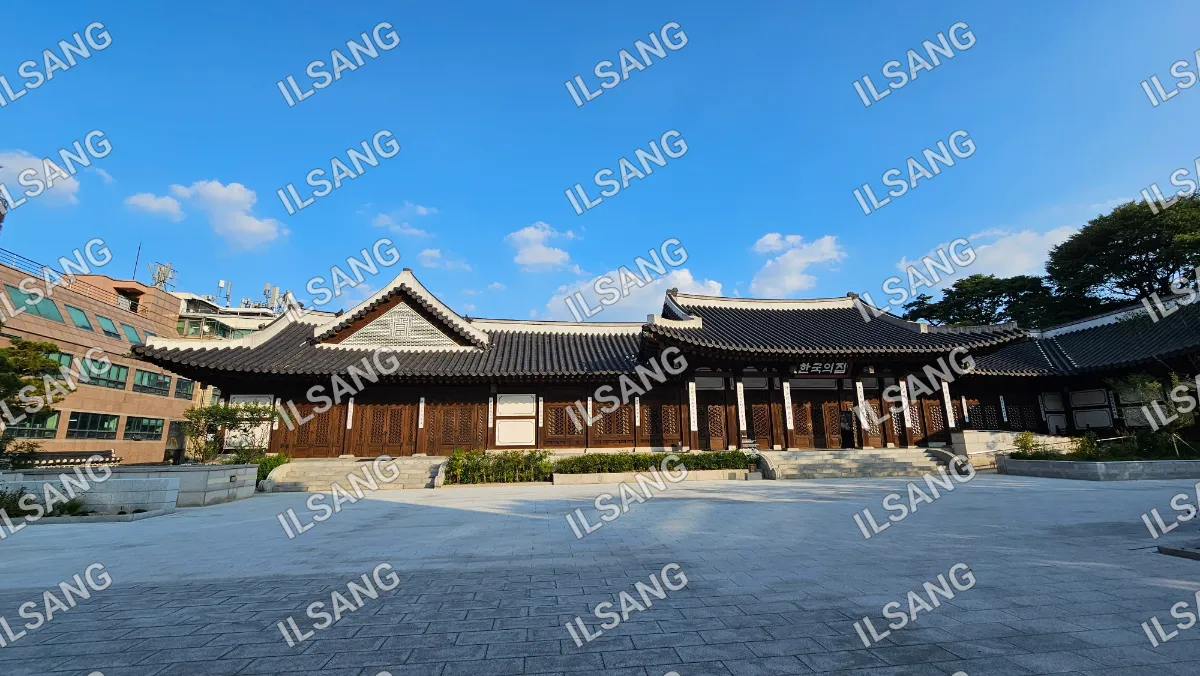 A large building with a white roof and a blue sky in the background.