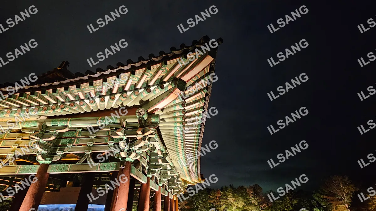 A large oriental building with a green roof and a red roof.