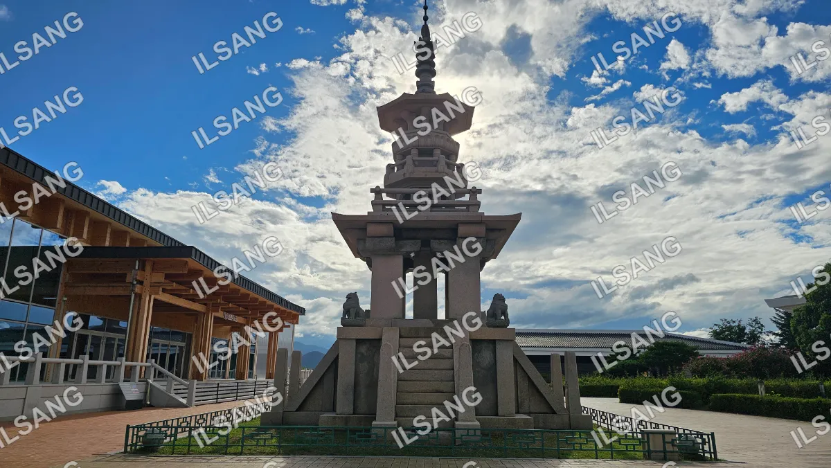 A large stone structure with a pagoda roof and a statue of a man and a woman on top.