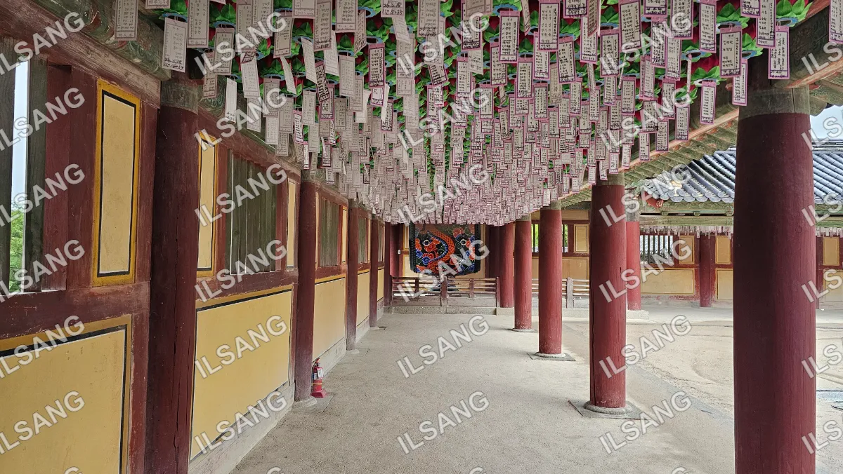 A long hallway with a red roof and a red wall.