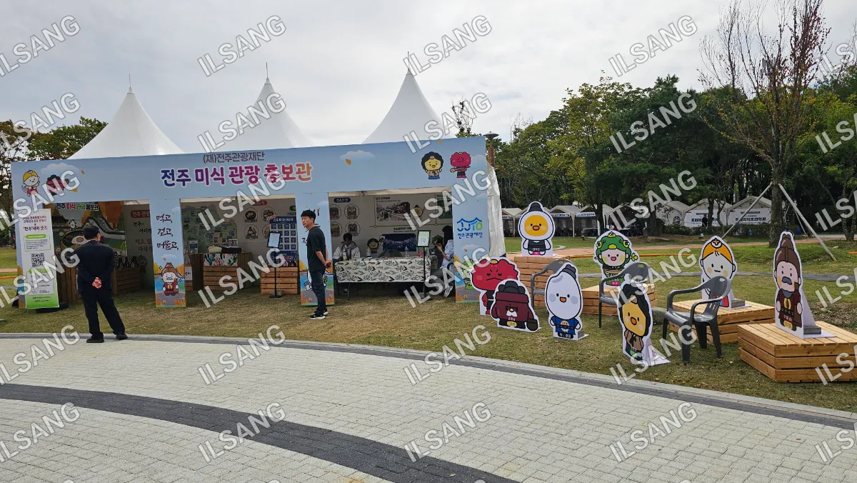 A man is standing in front of a tent with a sign that says "Korea".