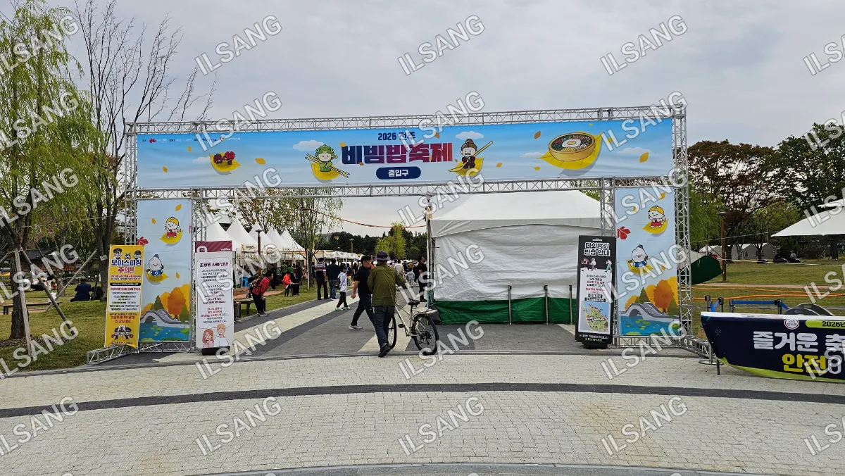 A man riding a bicycle in front of a large banner.