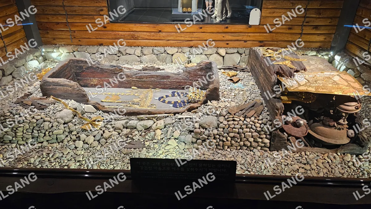A museum exhibit of a wooden boat with gold and jewels on display.