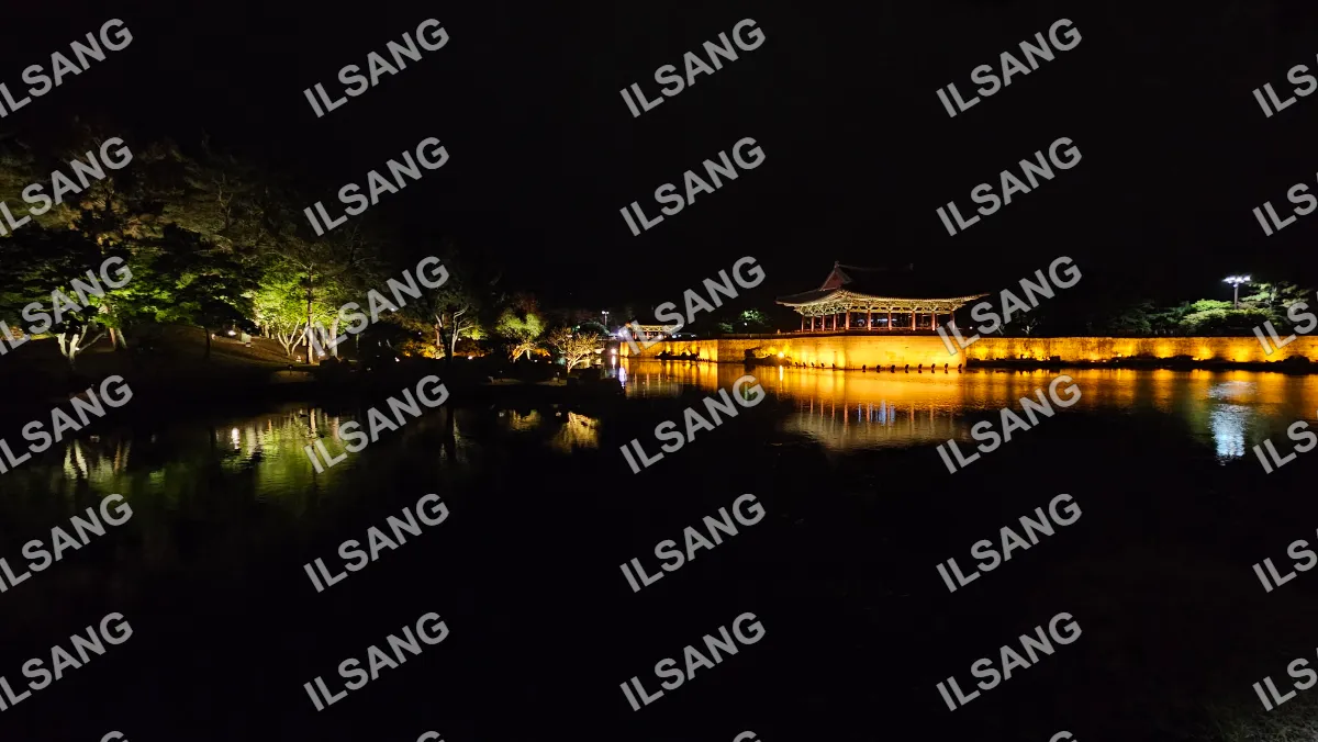 A nighttime view of a lake with a building in the background.