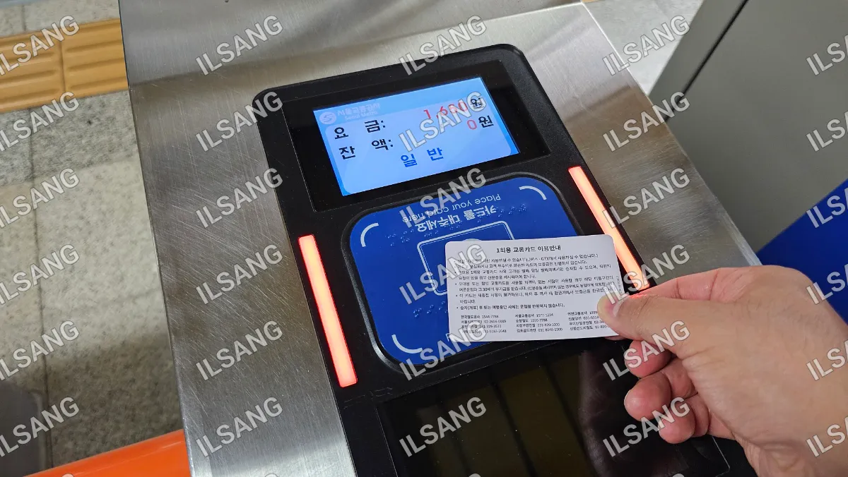 A person is holding a card in front of a machine.