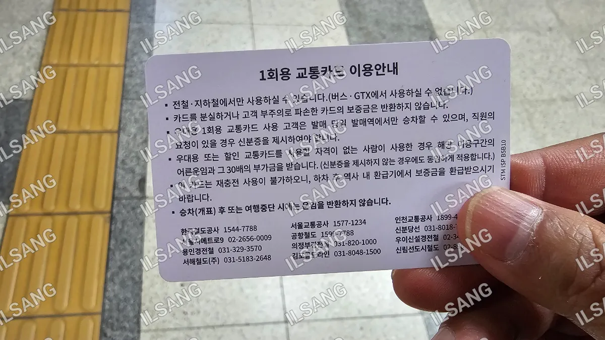 A person is holding a card with foreign writing on it.