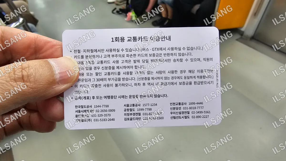 A person is holding a card with foreign writing on it.