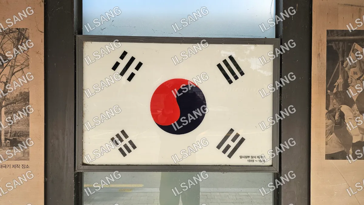 A person is standing in front of a window with a sign that has a red circle with a blue line through it.