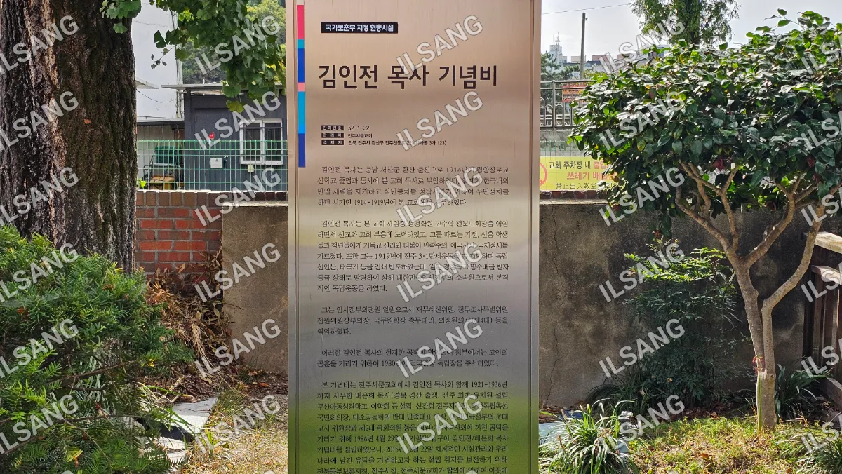 A plaque in a foreign language is mounted on a wall.