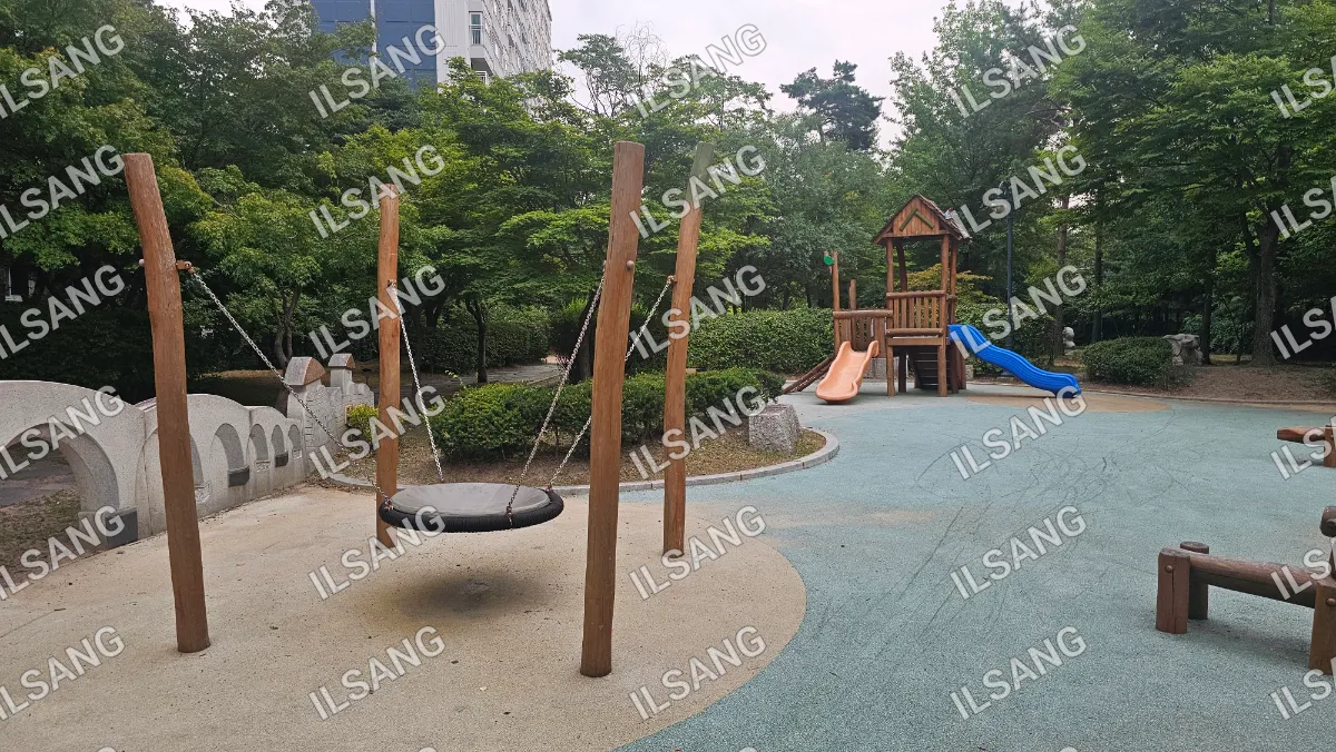 A playground with a swing, slide, and a small house.