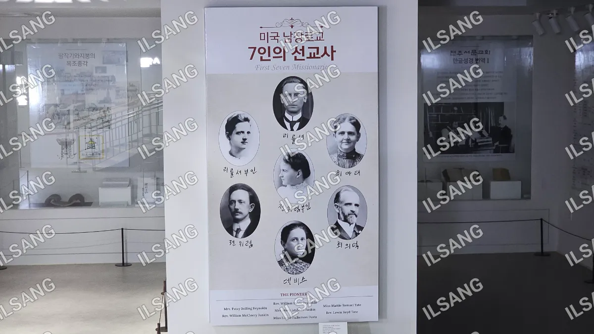 A poster of six people is displayed on a wall.