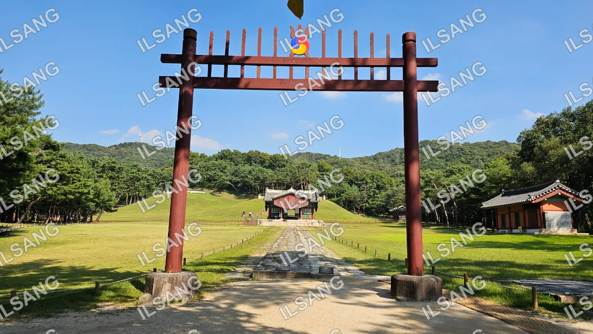 A red wooden archway with a blue and white sign on top.
