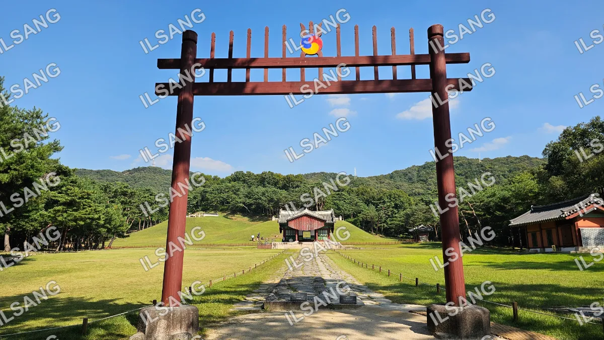 A red wooden archway with a yellow teddy bear on top.