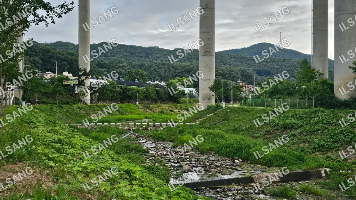 A river with a bridge and a concrete wall.