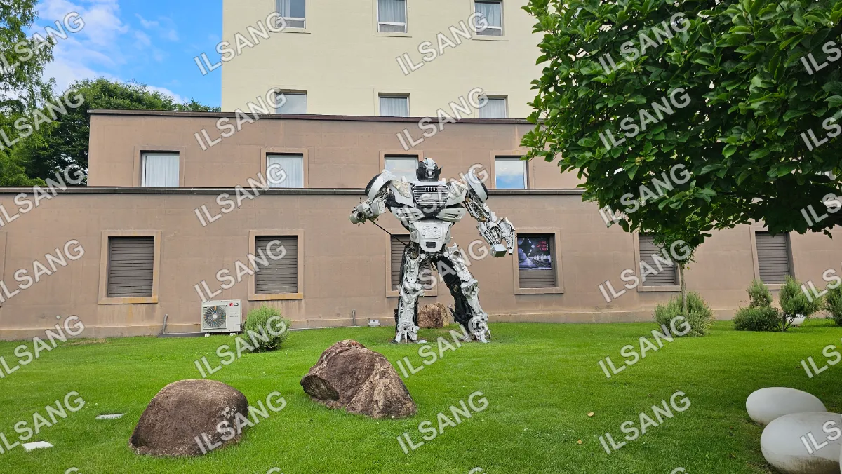 A robot statue is in front of a building.