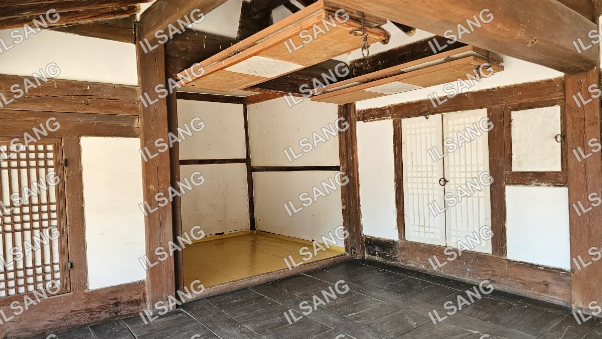 A room with a wooden door and a white wall.
