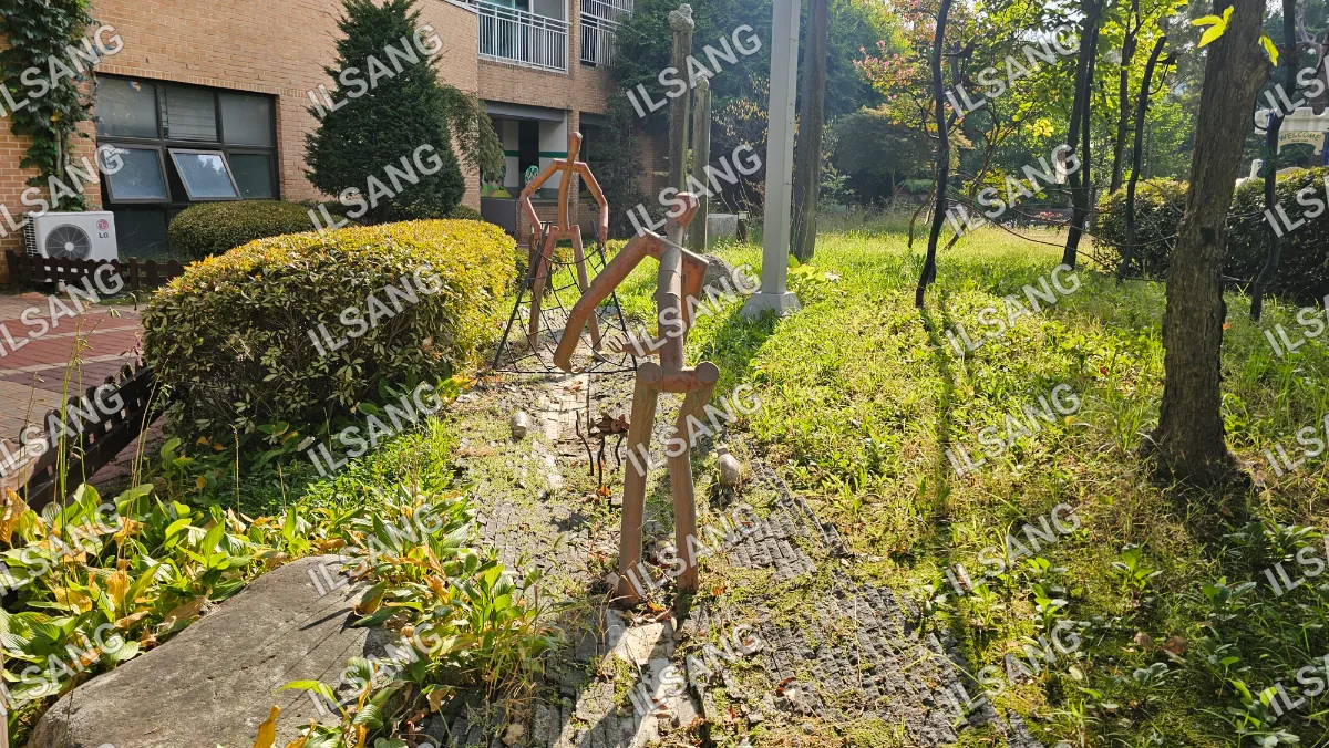 A set of three wooden statues are standing on a sidewalk.