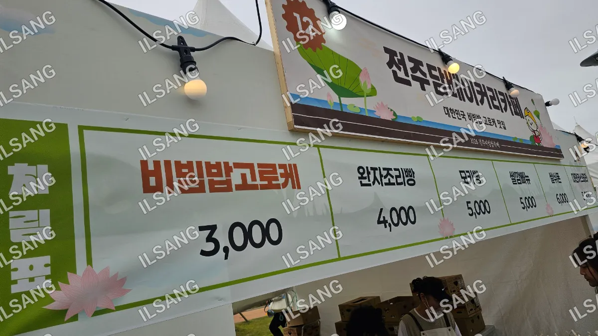A sign in a foreign language is displayed in front of a tent.