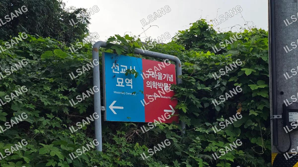 A sign in a foreign language is posted on a pole.