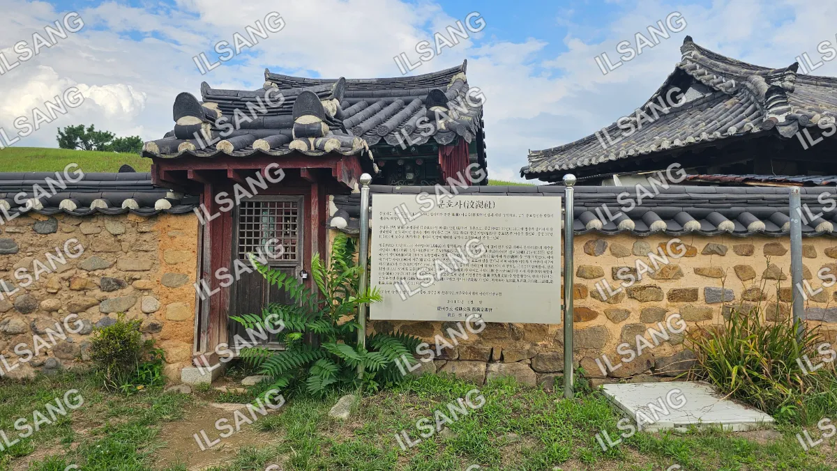 A sign in front of a building with a roof that is shaped like a Chinese roof.