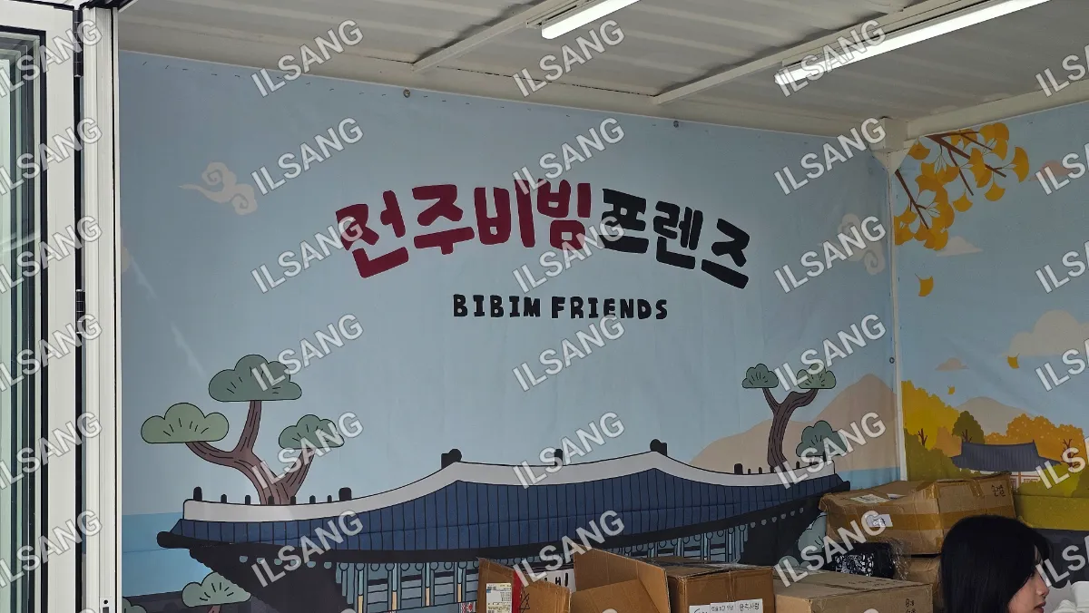 A sign written in a foreign language hangs on a wall.