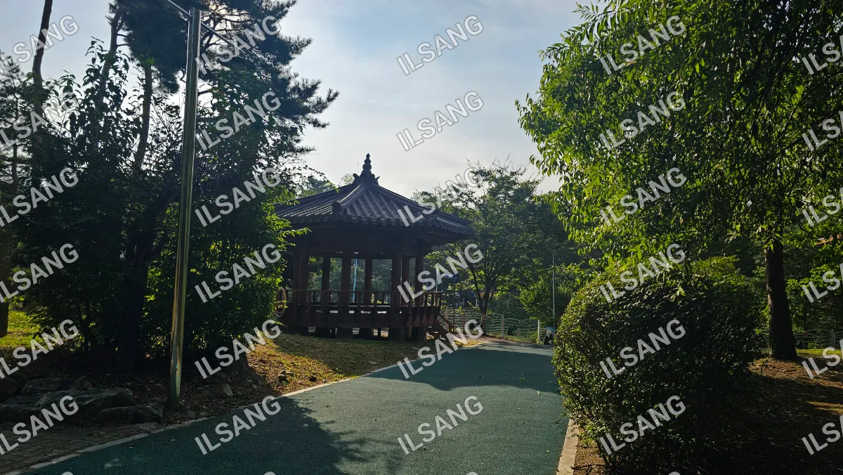 A small pavilion with a roof in a park.