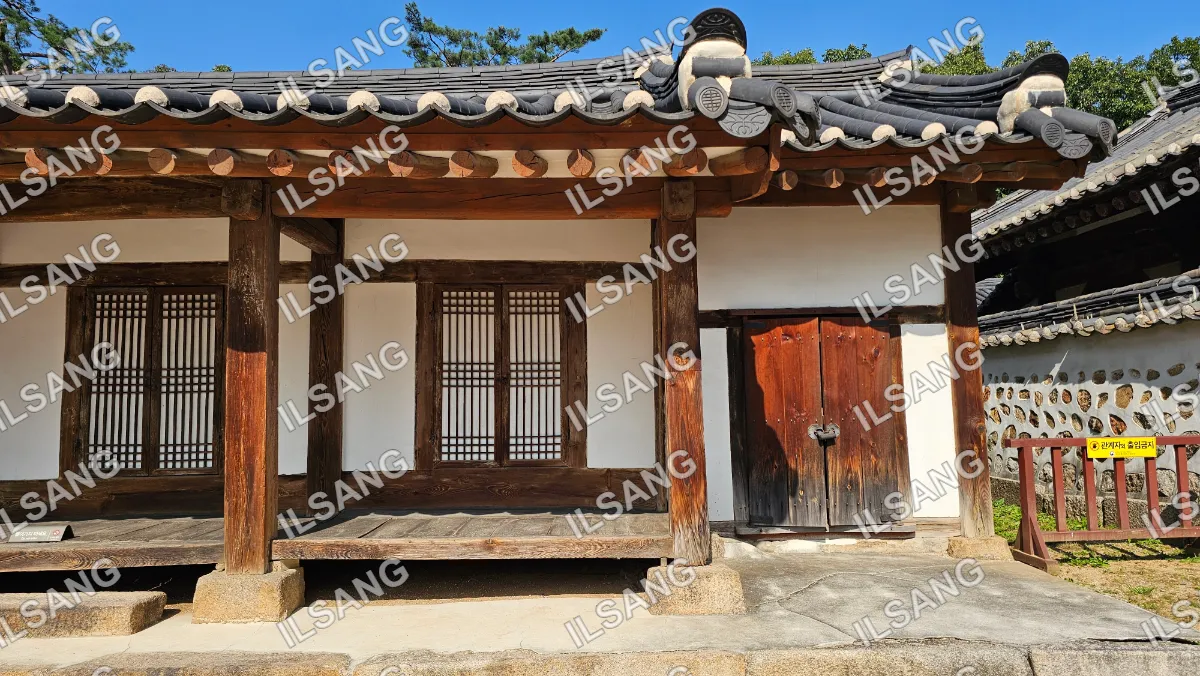 A small wooden house with a white roof.