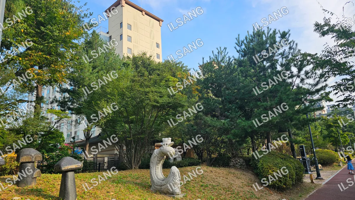 A statue of a dragon is in front of a building.