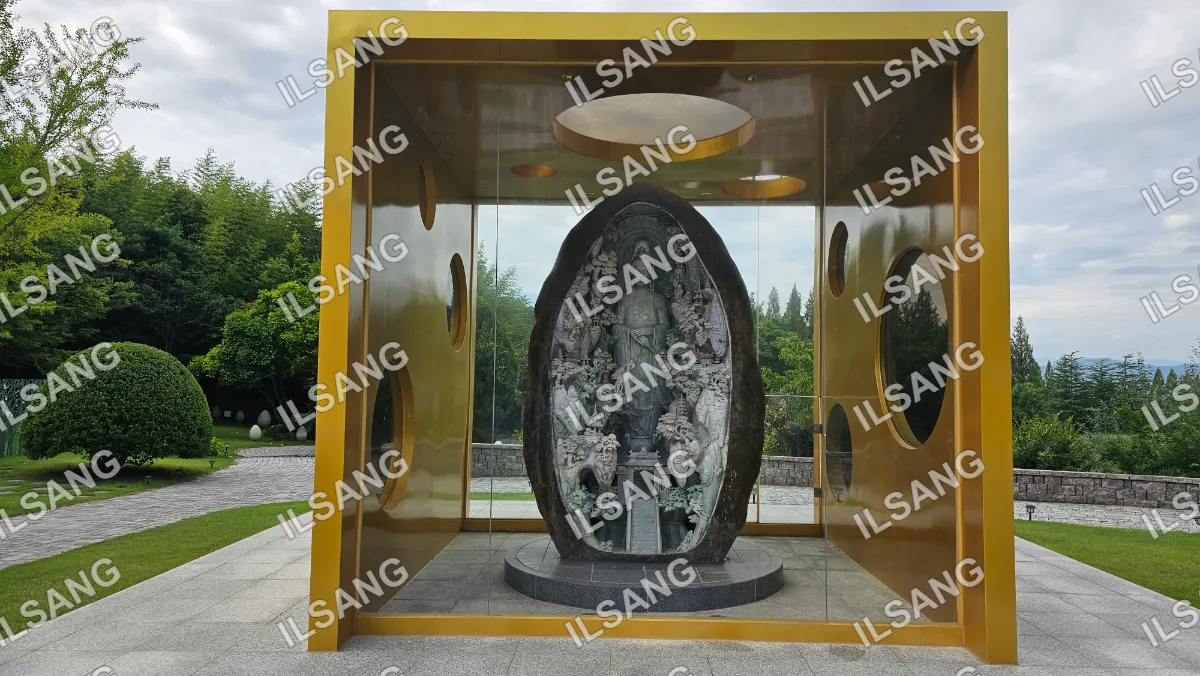 A statue of a person is inside a gold building.