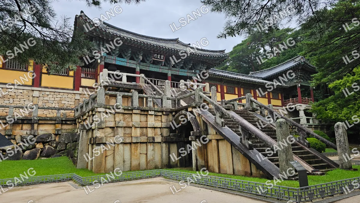 A stone building with a staircase leading to a doorway.