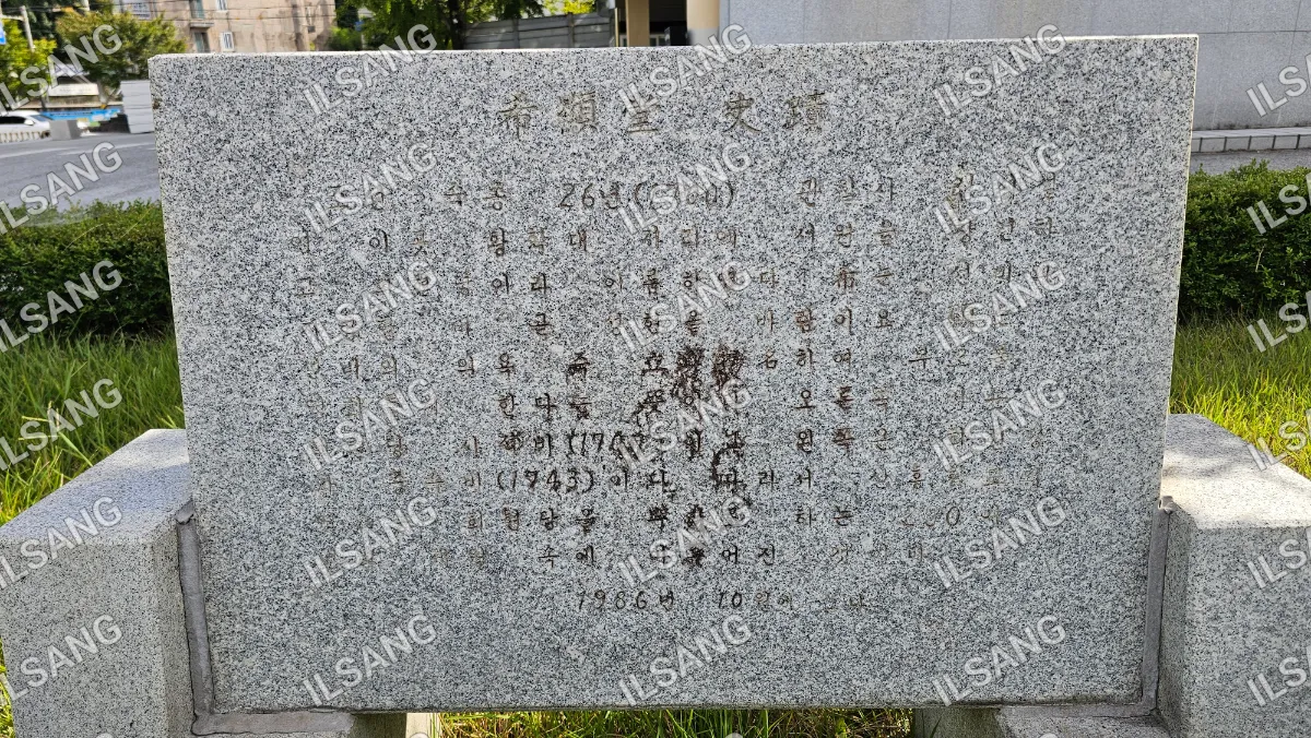 A stone monument with Asian writing on it.